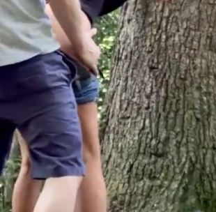 Horny teen leans on a tree and fucks